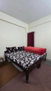 a bedroom with a large bed with red and black pillows at Shivpuri House Kedarnath in Kedārnāth +27 photos