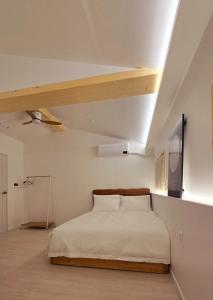 ein Schlafzimmer mit einem Bett und einem Fernseher an der Wand in der Unterkunft Moonlight Rooftop Retro Game Machine Large Jacuzzi Fire Healing Private Room Accommodation Parking Hanok Village in Jeonju