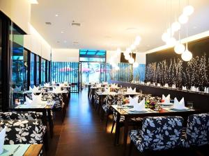 ein Restaurant mit Tischen und Stühlen und Weingläsern in der Unterkunft The Sez Hotel Bangsaen in Ban Laem Thaen