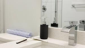 a bathroom sink with a blow dryer on a counter at Zillion’s Bliss - Basement Suite in Calgary +22 photos