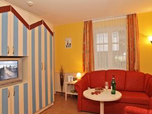 a living room with a red couch and a table at SEETELHOTEL Nautic Usedom Dünenhäuser in Ueckeritz