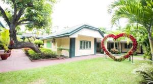 ein Haus mit einem herzförmigen Bogen im Hof in der Unterkunft Family Country Hotel and Convention Centre in Lagao