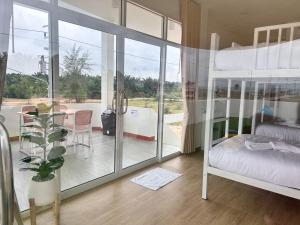 a bedroom with a bunk bed and a balcony at Heaven Thon Pool Villa in Narathiwat +24 photos