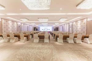 a large banquet hall with tables and chairs and a screen at Shaoxing Yintai Hotel in Shaoxing