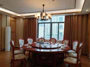 a dining room with a table and chairs and a large window at 7 Days Inn Fucheng Wu Gongci Gaodeng East Street Binjiang Road in Haikou