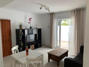 a living room with a couch and a table and a tv at Ferienwohnung Luna in Charco del Palo