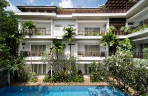 an apartment building with a swimming pool in front of it at Indra Angkor Residence in Siem Reap