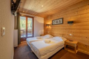 a bedroom with a bed in a wooden room at l'Ours Bleu C21 - Ski In Ski Out - Happy Rentals in Vallorcine