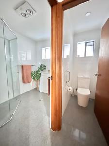 a bathroom with a toilet and a glass shower at Casa Al Mare- family and pet friendly, close to everything in Gold Coast