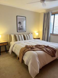 a large white bed in a bedroom with a window at Casa Al Mare- family and pet friendly, close to everything in Gold Coast