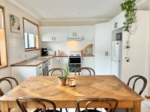 a kitchen with a wooden table and chairs at Casa Al Mare- family and pet friendly, close to everything in Gold Coast +23 photos