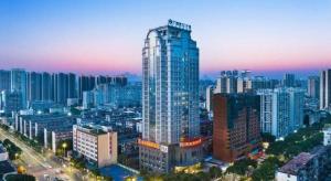 a tall building in a city at night at Vienna International Hotel Nanning Railway Station Mingxiu Road Metro Station in Nanning