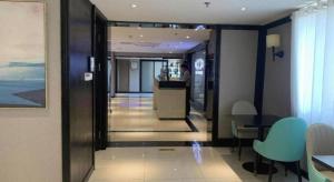 un couloir d'un hôtel avec une table et des chaises dans l'établissement Xana Hotelle Jinan Daminghu North Gate, à Jinan