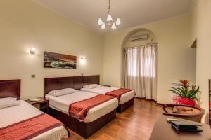 ローマにあるNew albatrosのベッド2台とテーブルが備わるホテルルームです。