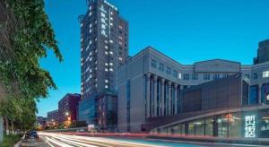 a tall building in a city at night at Lavande Hotels Urumqi Xinmin West Street Hongda Plaza in Ürümqi