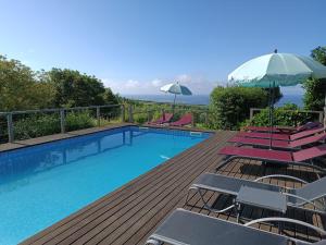 ein Swimmingpool mit Stühlen und einem Sonnenschirm in der Unterkunft Casa Do Tanque in Nordestinho