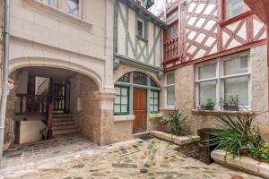 an old building with an arched doorway and windows at Blois hypercentre, calme, charme avec terrasse in Blois