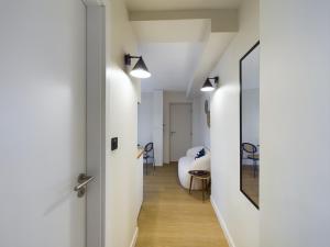 einen Flur, der zu einem Zimmer mit einem Bett und einem Spiegel führt in der Unterkunft Charmant 2 pièces très calme aux pieds de la Cathédrale in Straßburg