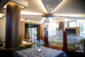 Una habitación con una mesa con un jarrón de flores encima. en Hotiday Conegliano, en Conegliano