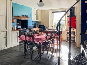 a kitchen and dining room with a table and chairs at Downhouse in Delabole