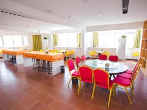 a dining room with tables and chairs and windows at IU Hotel Baoding Yuhua East Road Passenger Center in Baoding