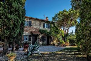 ein altes Steinhaus mit Bäumen davor in der Unterkunft Casa Terra Rossa in Fauglia