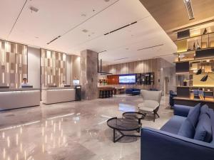 - un hall avec des canapés, des chaises et une télévision dans l'établissement Echarm Hotel Enshi Cultural Center Xintiandi, à Enshi