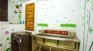 a washing machine in a room with butterflies on the wall at JTOUR Inn Wuzhou Arcade City Sanzongfu in Wuzhou