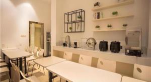 ein Esszimmer mit Tischen, Stühlen und einer Theke in der Unterkunft City Comfort Inn Nanchang Guanying Road Metro Station Maya Paradise in Nanchang