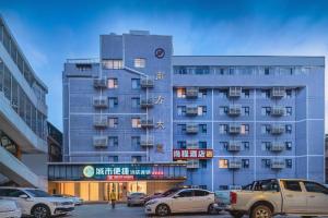 un bâtiment avec des voitures garées devant dans l'établissement City Comfort Inn Liuzhou High-speed Railway Station, à Liuzhou