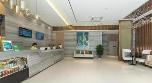 eine Frau steht an einer Theke in einem Geschäft in der Unterkunft City Comfort Inn Guigang Hecheng Wanda Plaza in Guigang