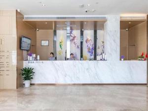 a lobby with a counter with people standing behind it at Lavande Hotels· Suizhou Wenfeng in Suizhou
