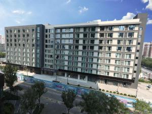 a large white building with a street in front of it at Lavande Hotel Beijing Fangshan Changyang Metro Station in Pei-kang-wa