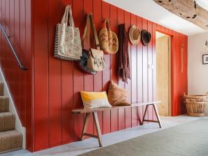 a room with a red wall with a bench and purses at Blaenau - Uk50400 in Llanstephan