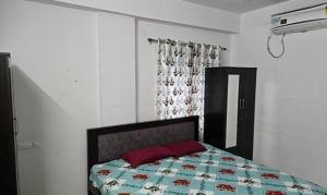 a bedroom with a bed with a quilt on it at FabHotel RK Grand in Hyderabad