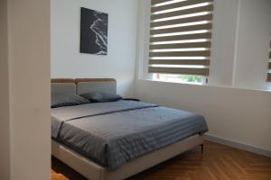 a bed in a white room with a window at GIA Hotel & Serviced Apartment in Nhơn Trạch +22 photos