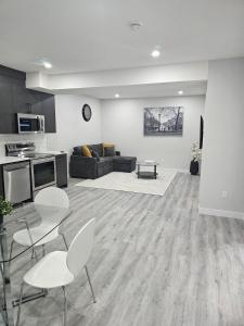a living room with a couch and a table and chairs at Cozy on Baywater in Airdrie