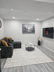 a living room with a couch and a table at Cozy on Baywater in Airdrie