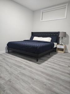 a bedroom with a bed in a white room at Cozy on Baywater in Airdrie