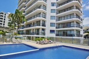 a building with a swimming pool in front of a building at Stay in Seaview Resort, 2 BD apartment with ocean views in Mooloolaba