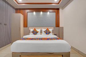 a bedroom with a large white bed with colorful pillows at Hotel Rohan Palace in Vrindāvan