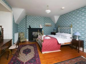 a bedroom with a bed and a fireplace at Ballealy Cottage in Randalstown