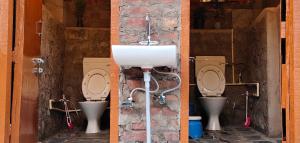 a bathroom with two toilets and a sink at Khoj Cottage & Cafe in Dharmsāla