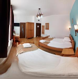 トゥルグ・ムレシュにあるPensiunea Muresulのベッド2台とテーブルが備わる客室です。