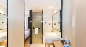 ein Badezimmer mit Dusche, Waschbecken und Spiegel in der Unterkunft Gya Hotel Shanghai Xizang Bei Road Metro Station in Shanghai + 115 Fotos