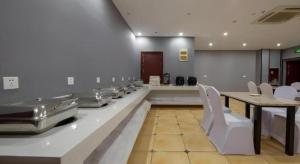 a large room with a table and white chairs at GreenTree Alliance Hotel Changzhou Tibet National Middle School Chenduqiao in Changzhou