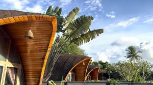 a house with a palm tree in front of it at Found Mansion Langkawi in Pantai Cenang