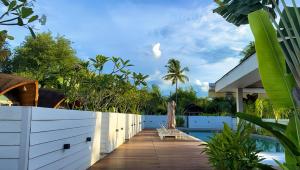a wooden walkway next to a fence next to a swimming pool at Found Mansion Langkawi in Pantai Cenang +101 photos