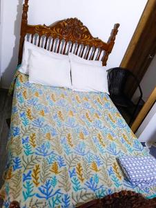a bed with a blue and yellow quilt on it at habitacion en casa de familia in Rionegro