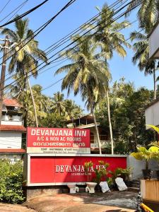 a sign in front of a building with palm trees at devanjana inn in Jāmb